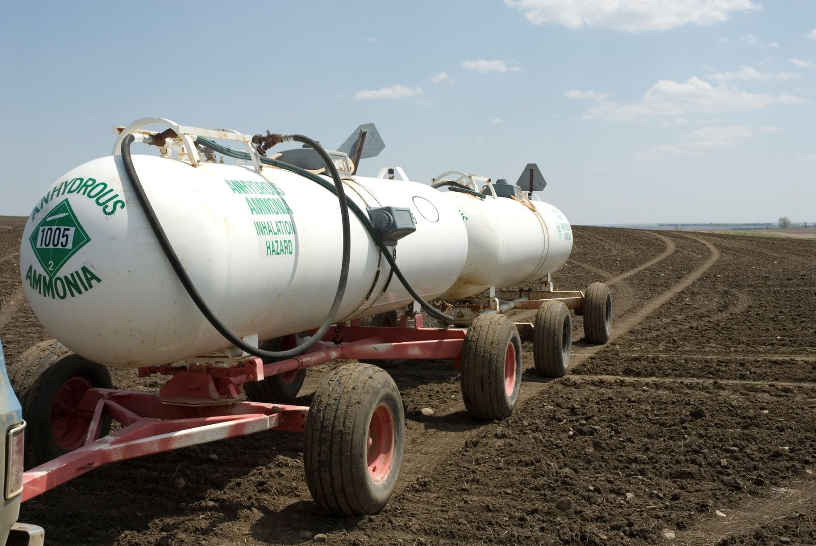 Anhydrous ammonia nurse tanks beside a field