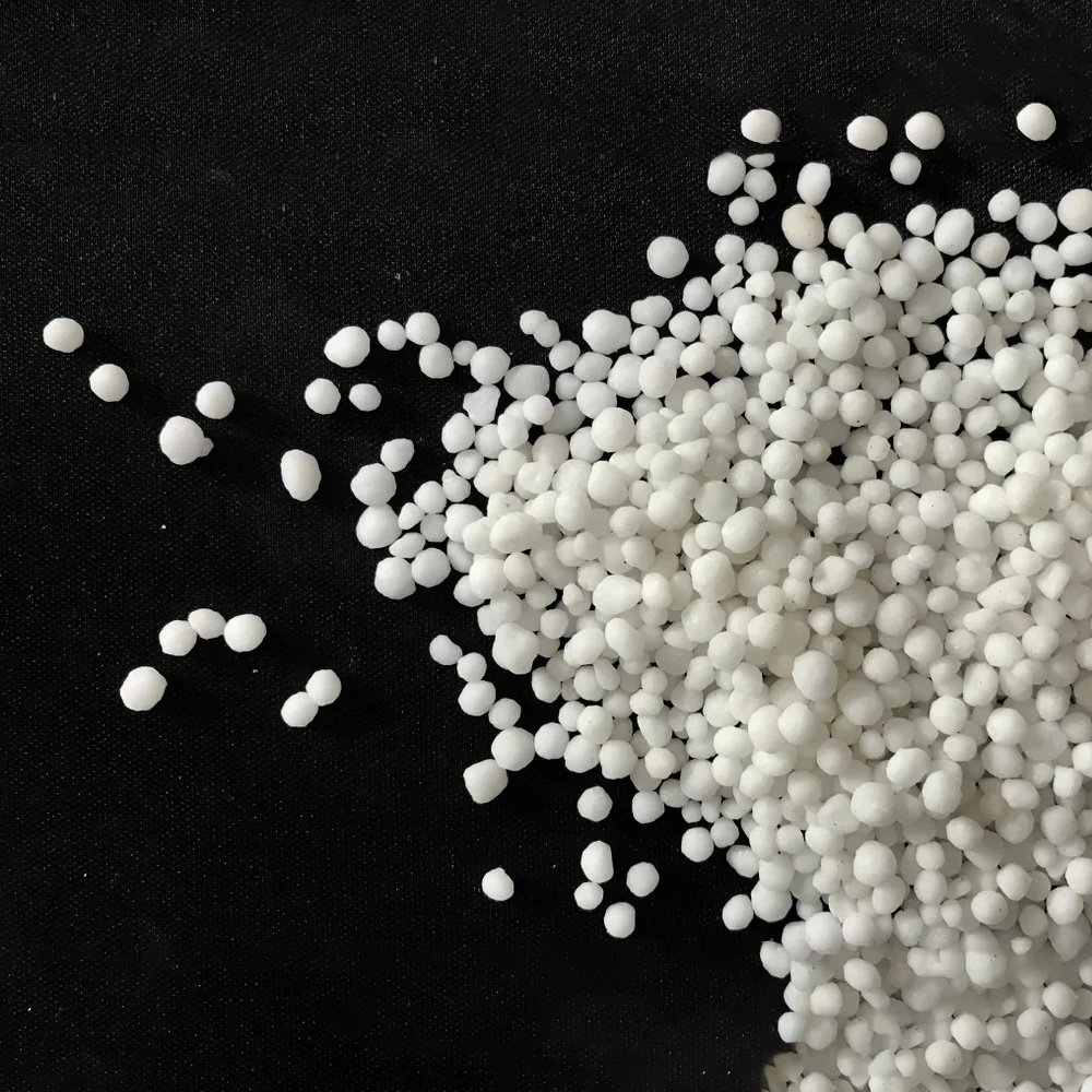 White granular urea on a dark surface
